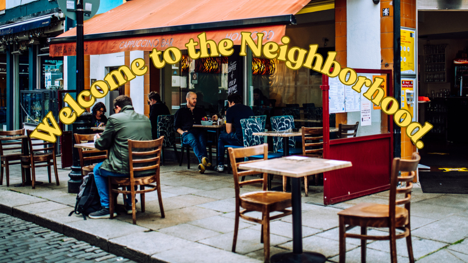 The outside of Cappuccino Bar in Temple Bar, Dublin, Ireland with yellow text that reads "welcome to the neighborhood."